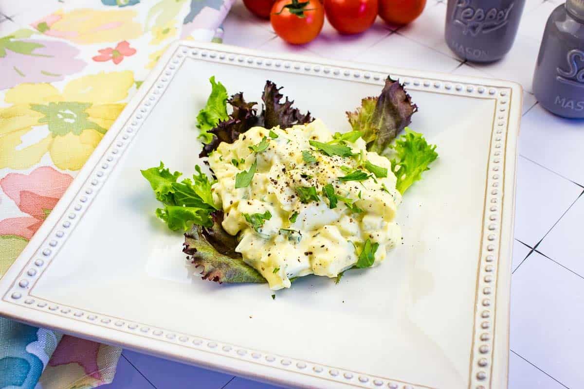 Egg salad on a white square plate.