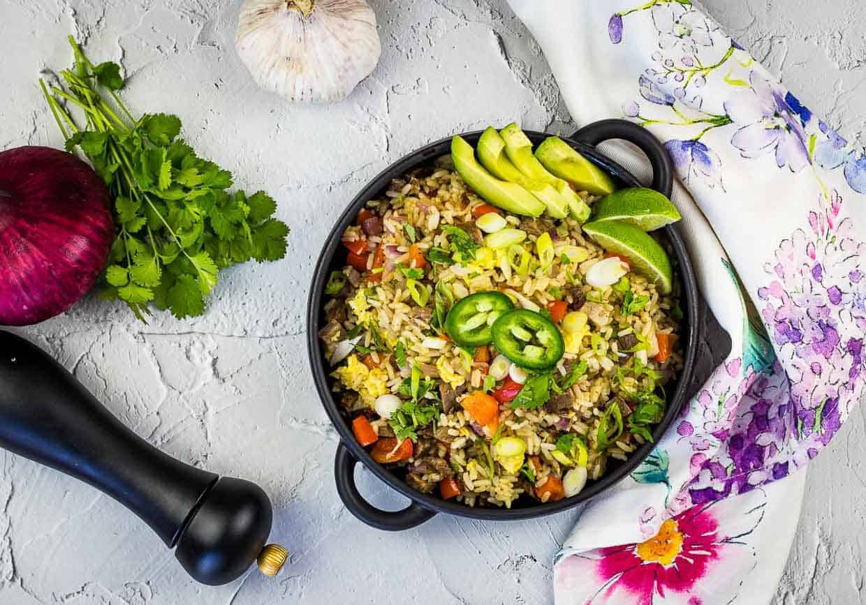 A top down shot of Brisket Fried Rice with vegetables nearby.