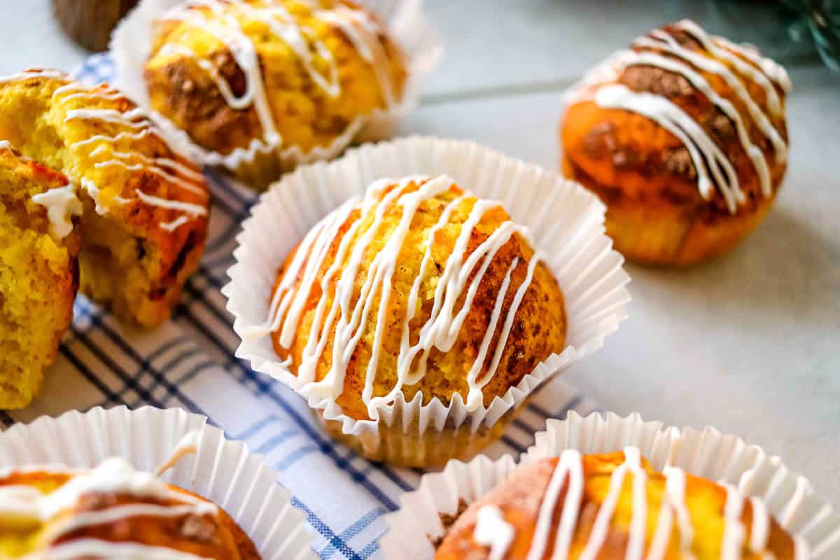 Muffins with white icing on a blue napkin.