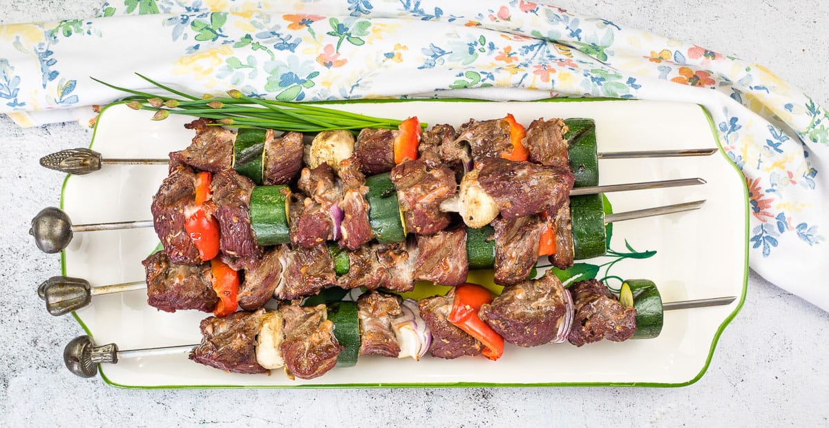 Smoked beef kabobs on a plate.