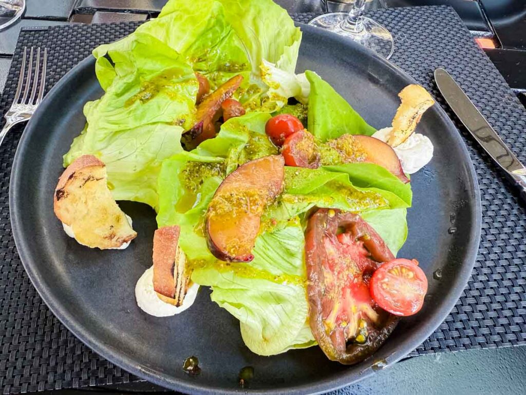 A dish with lettuce and tomatoes on it.