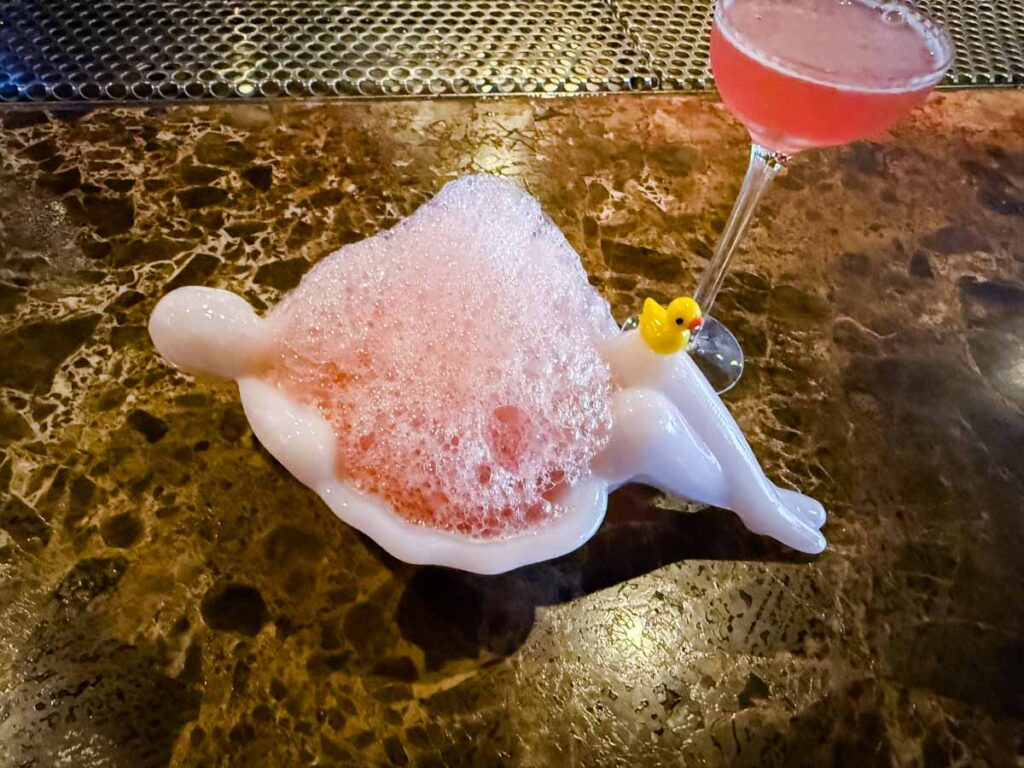Drink served in a small bathtub with a duck figurine.