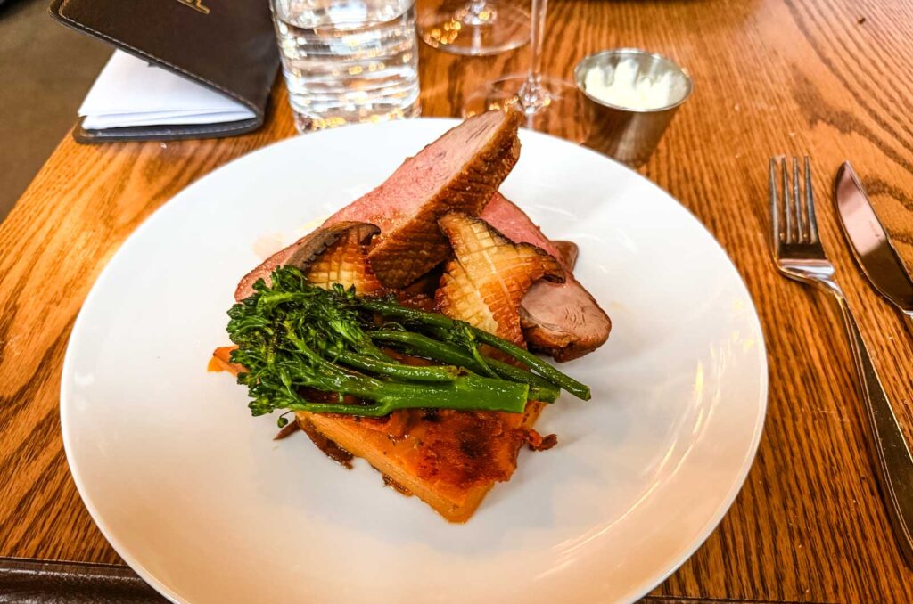 Duck breast entree on a plate.